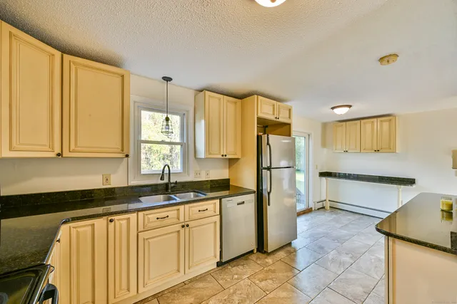 a kitchen with stainless steel appliances a refrigerator sink and cabinets