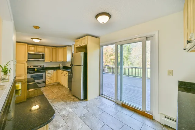 a large kitchen with kitchen island granite countertop a sink and stainless steel appliances