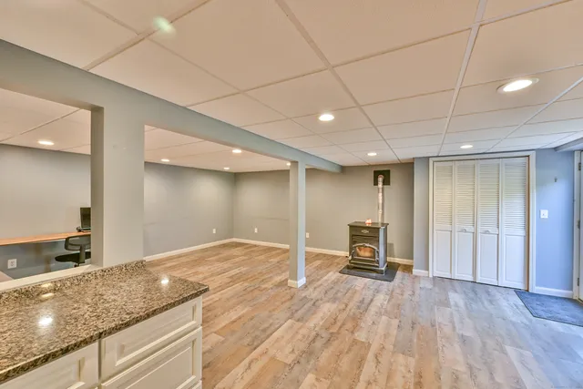 a view of kitchen with kitchen island granite countertop a stove and a refrigerator with cabinets