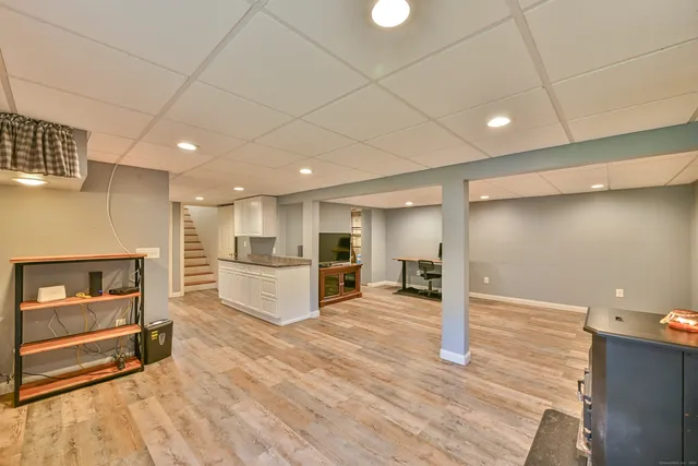 a view of a livingroom with furniture a flat screen tv and wooden floor
