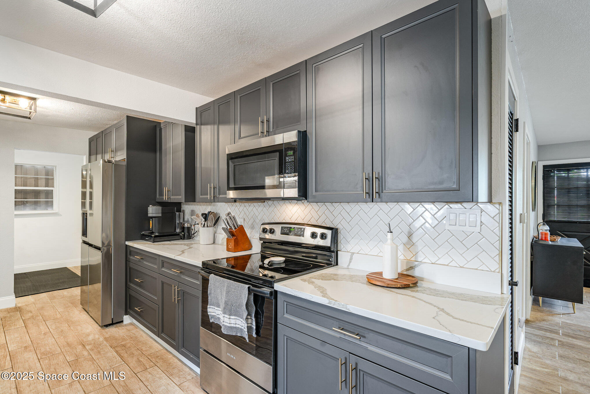 508 Comanche Avenue Melbourne, FL 32935 - Photo 10 of 21 a kitchen with stainless steel appliances granite countertop a sink stove microwave and refrigerator