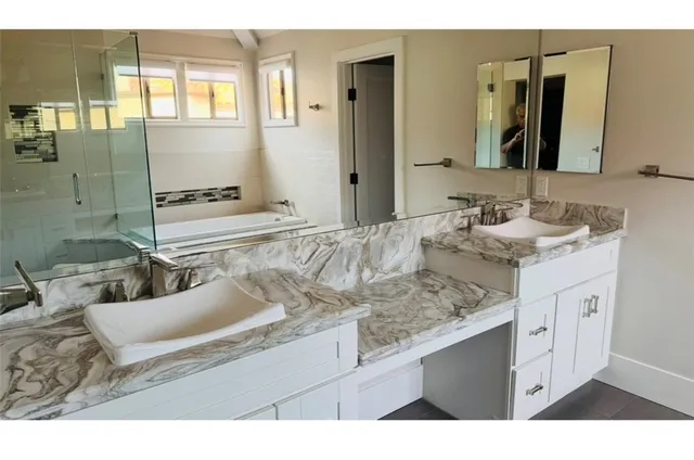 a bathroom with a sink double vanity granite and a mirror