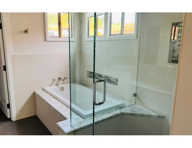 a bathroom with a tub and shower