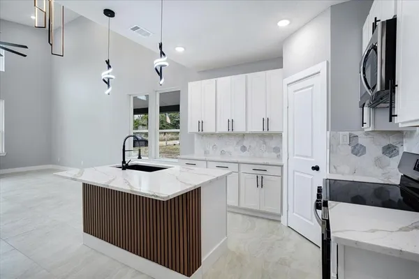 a kitchen with a sink dishwasher a stove and a refrigerator with wooden floor