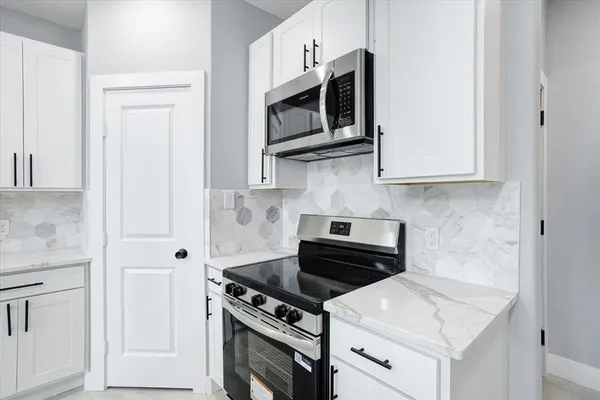 a kitchen with stainless steel appliances white cabinets and stove