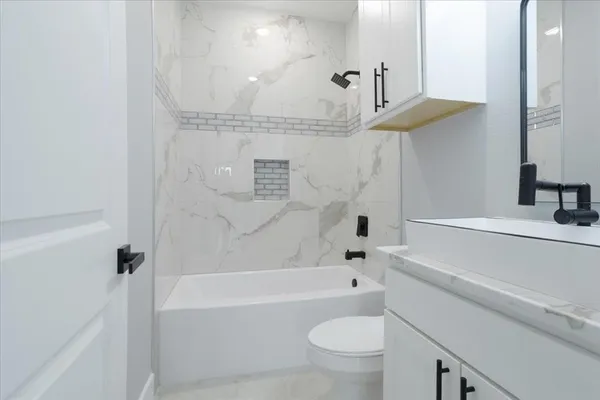 a bathroom with a bathtub a toilet a sink and a shower