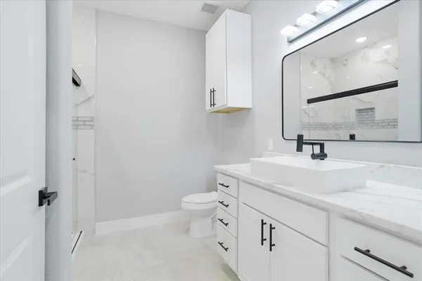 a bathroom with a sink a toilet and mirror