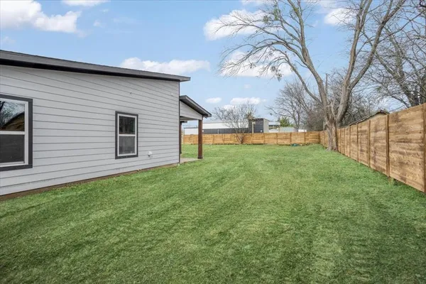 a backyard of a house with table and chairs