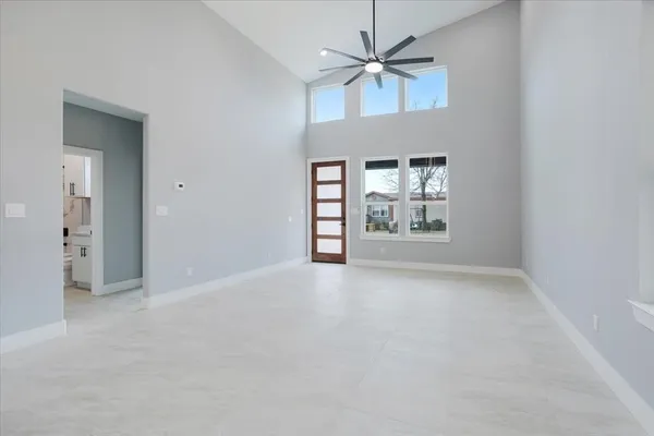 en empty room with windows and ceiling fan