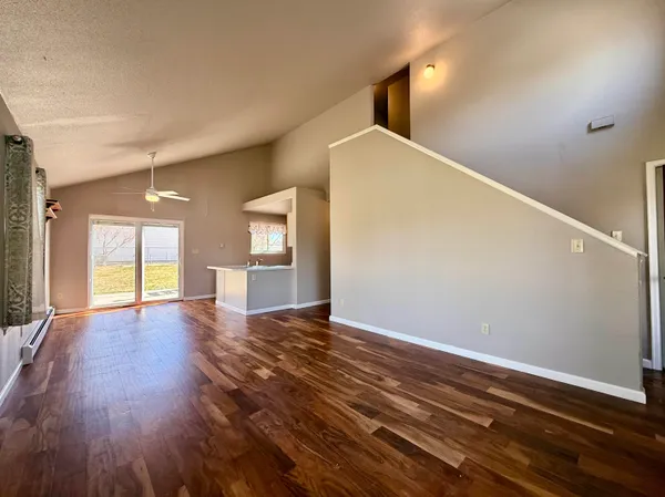 a view of a livingroom with a window and wooden floor