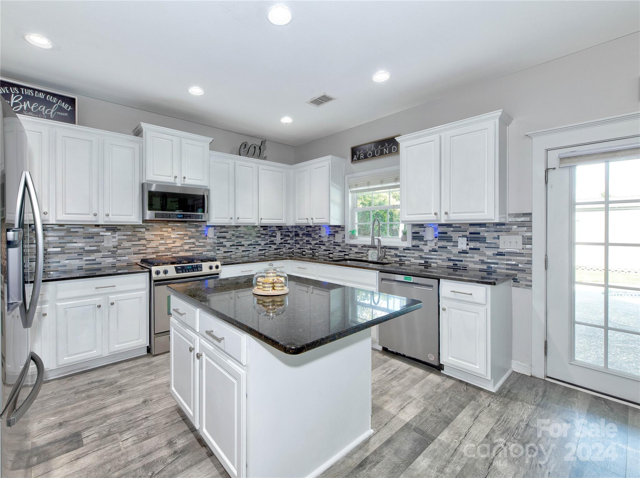 3002 Potomac Road Indian Trail, NC 28079 - Photo 11 of 48 a kitchen with stainless steel appliances granite countertop a sink stove microwave and cabinets