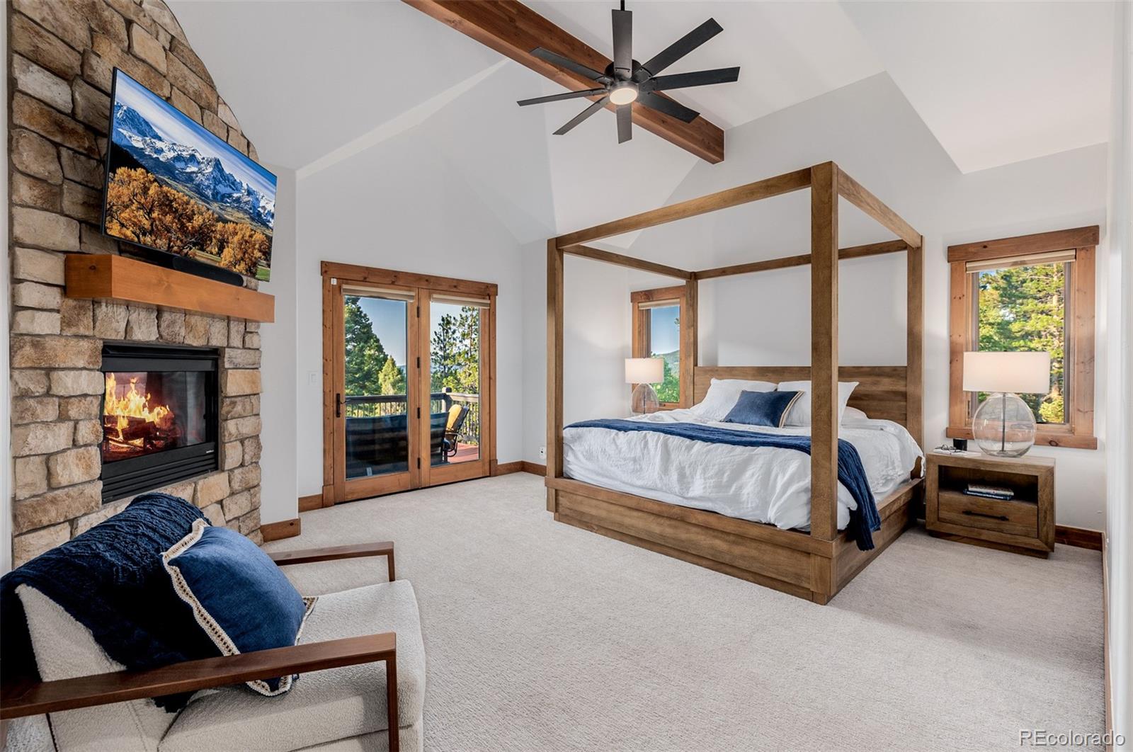 11272 Belle Meade Drive Conifer, CO 80433 - Photo 23 of 45 a bedroom with a bed and a chandelier