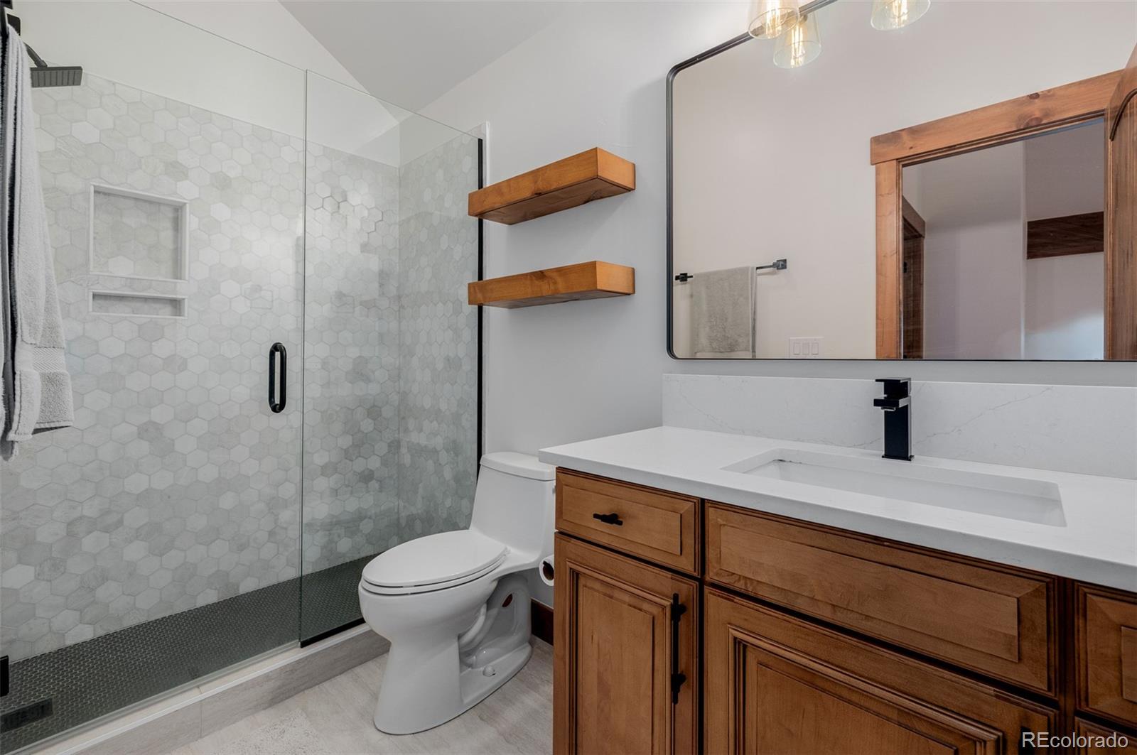 11272 Belle Meade Drive Conifer, CO 80433 - Photo 31 of 45 a bathroom with a sink a toilet and shower