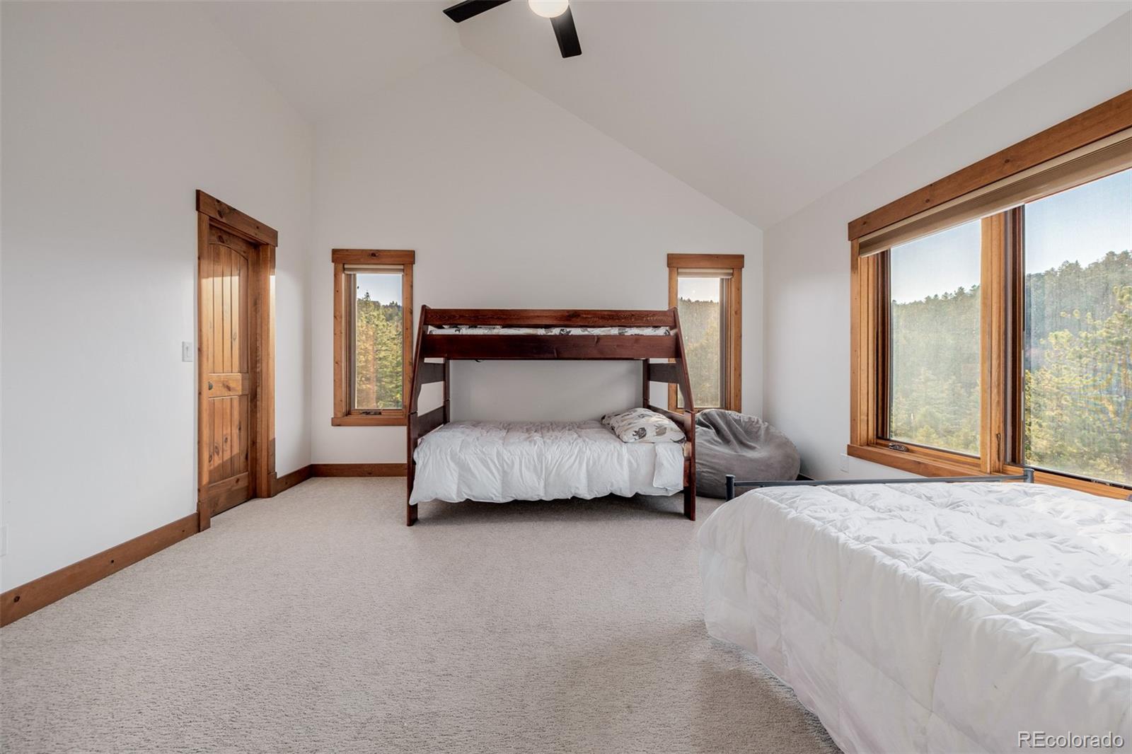 11272 Belle Meade Drive Conifer, CO 80433 - Photo 33 of 45 a bedroom with a bed and large windows