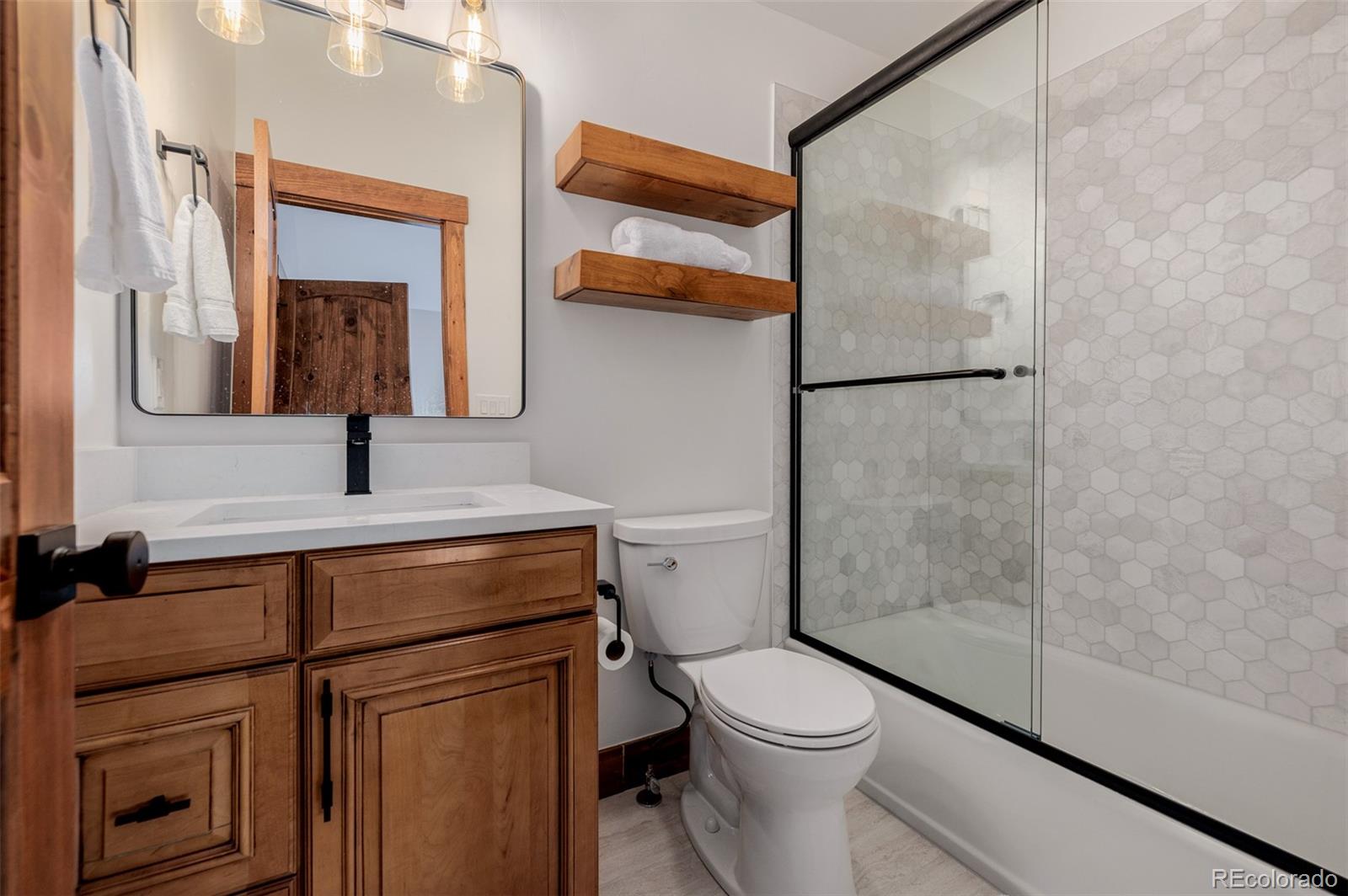 11272 Belle Meade Drive Conifer, CO 80433 - Photo 34 of 45 a bathroom with a toilet a sink and mirror