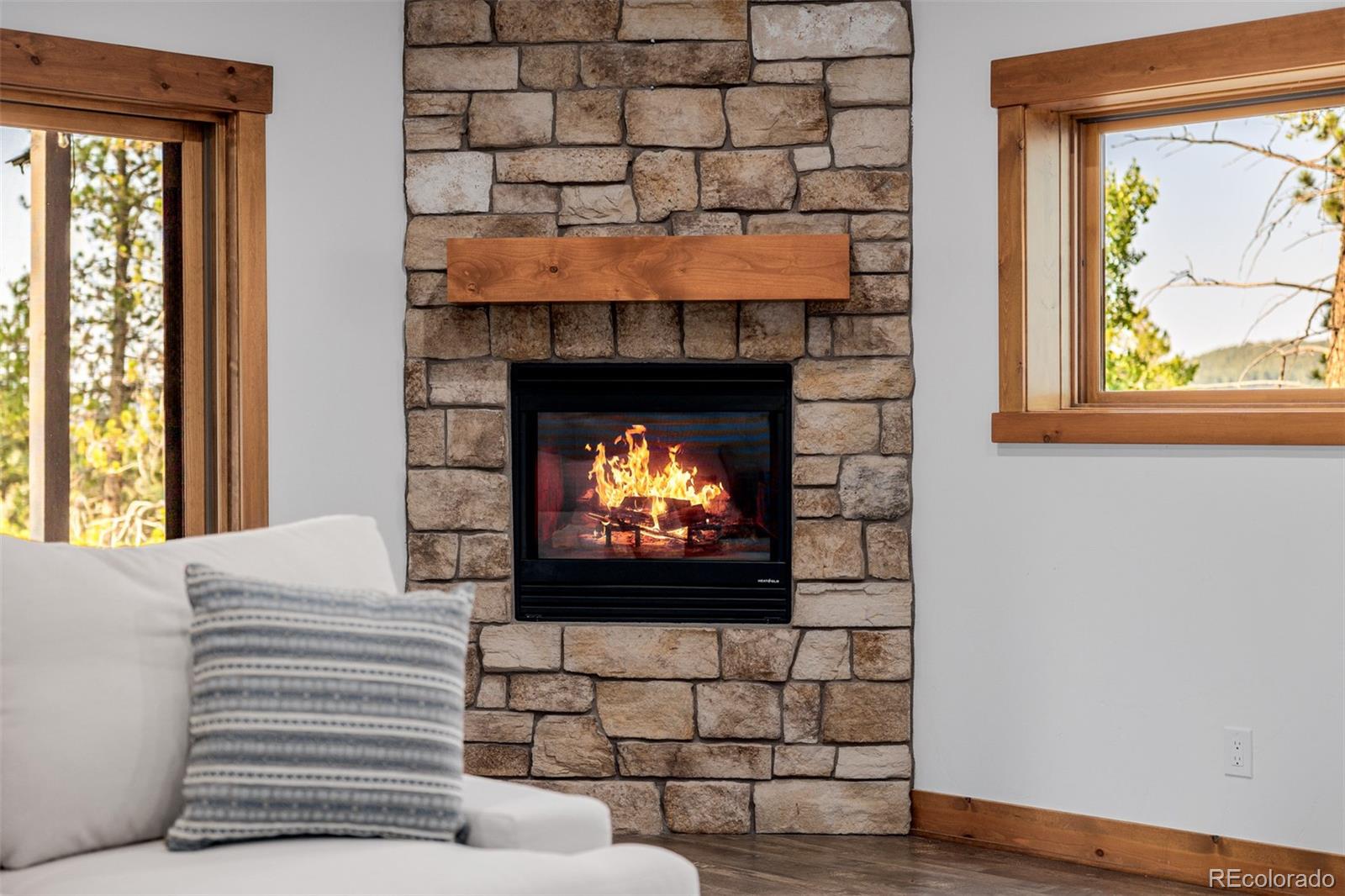 11272 Belle Meade Drive Conifer, CO 80433 - Photo 36 of 45 a living room with a fireplace and a flat screen tv