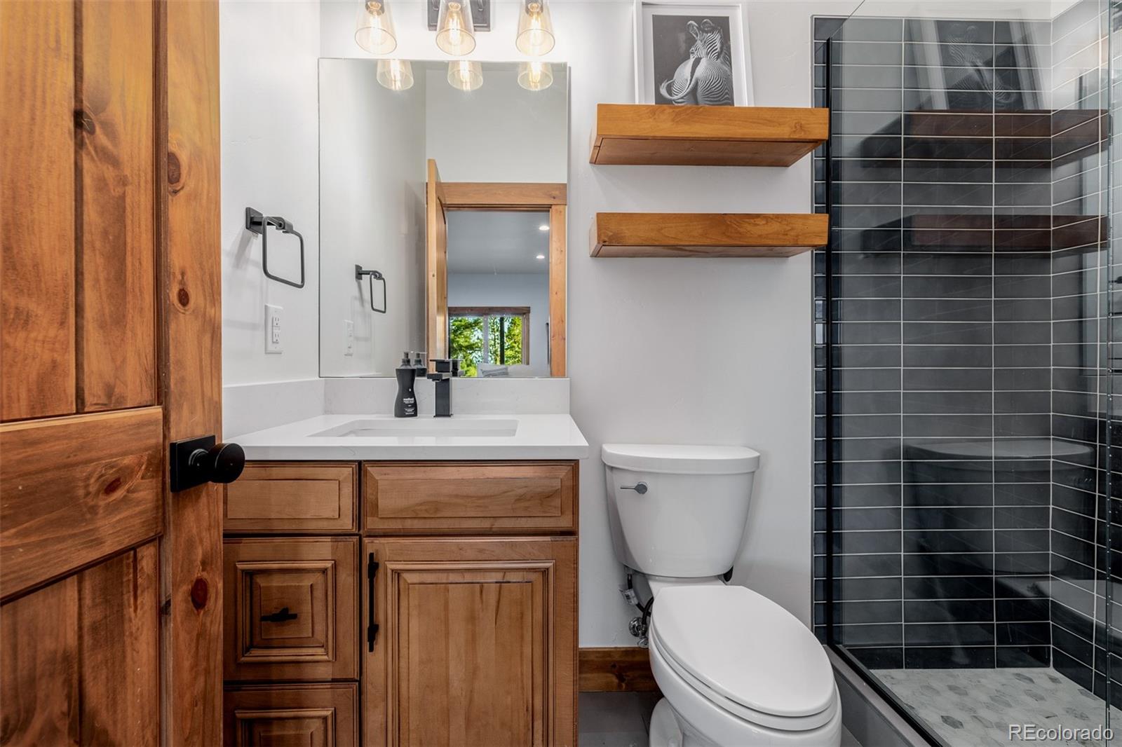 11272 Belle Meade Drive Conifer, CO 80433 - Photo 38 of 45 a bathroom with a toilet a sink and shower