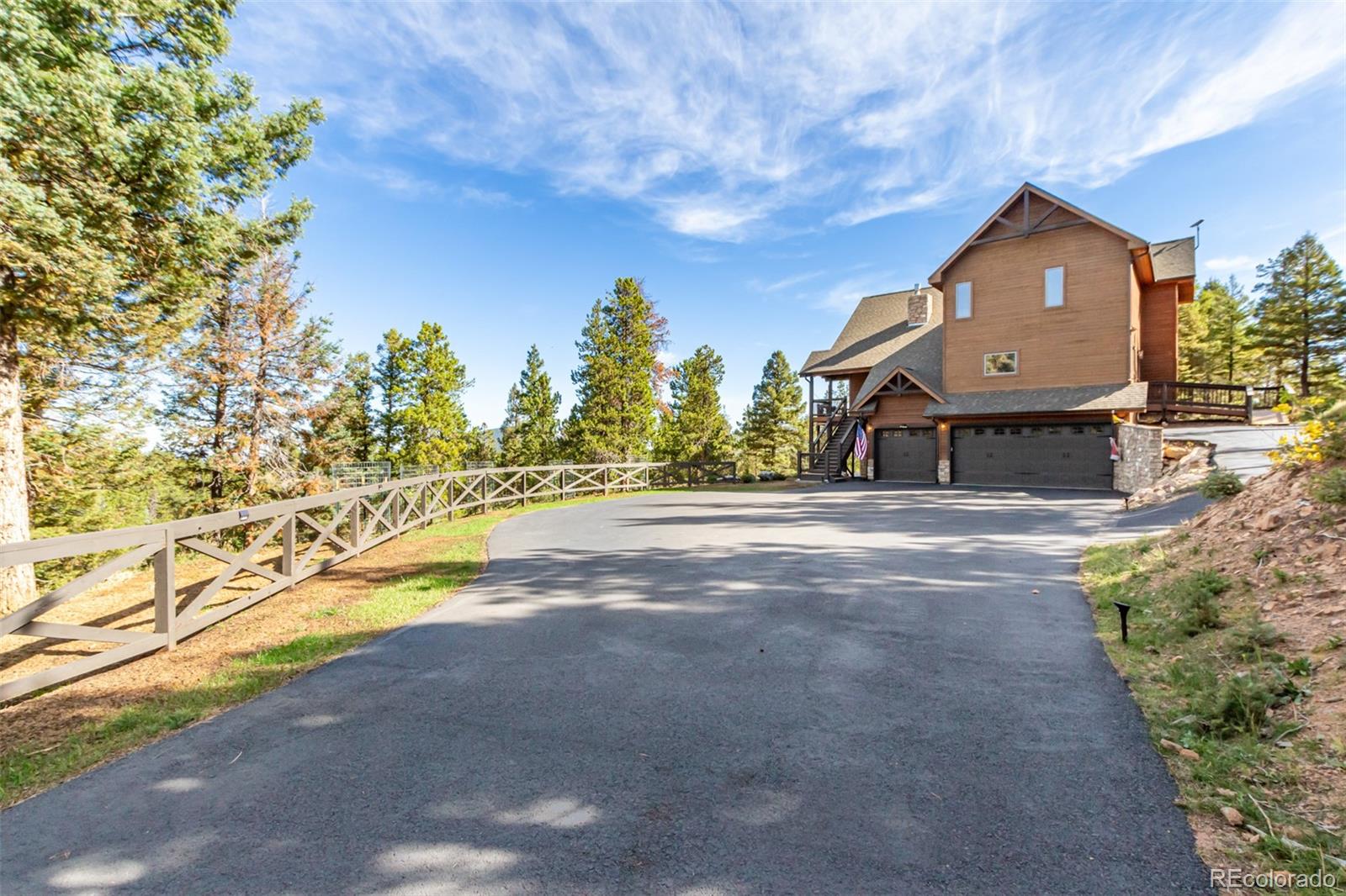 11272 Belle Meade Drive Conifer, CO 80433 - Photo 41 of 45 a front view of a house with a yard and a large tree