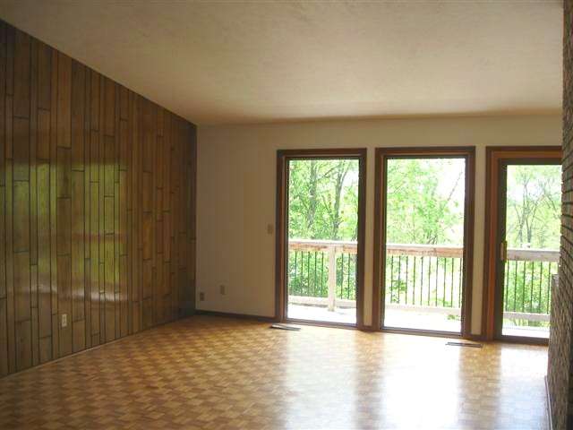 14172 Hauley Road Durand, IL 61024 - Photo 2 of 9 an empty room with wooden floor and windows