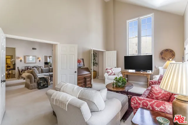 a living room with furniture a flat screen tv and a large window