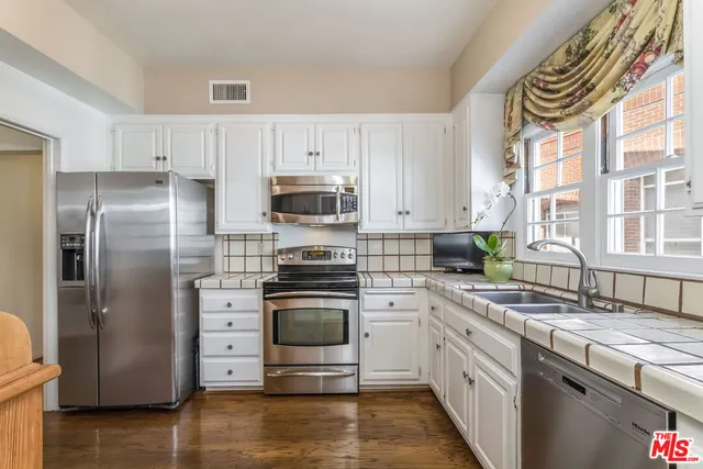 a kitchen with stainless steel appliances a refrigerator sink and stove