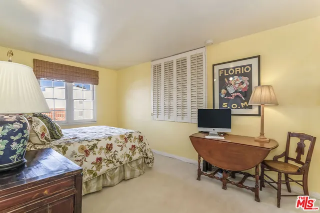 a bedroom with a bed and a desk