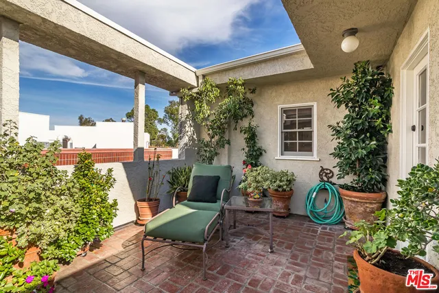 a view of a chair and table in back yard of the house