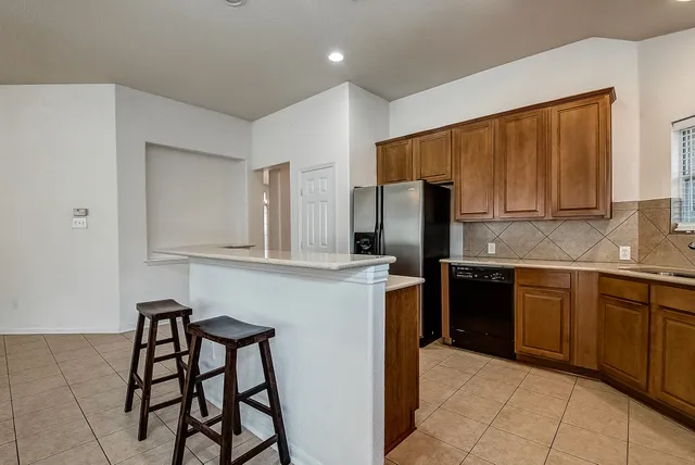 a kitchen with stainless steel appliances a refrigerator and a stove top oven