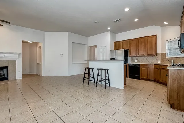 a view of an empty room with a fireplace and a window