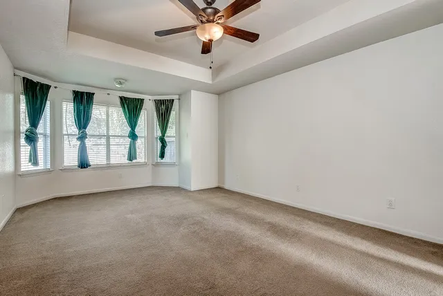 a view of an empty room with a ceiling fan