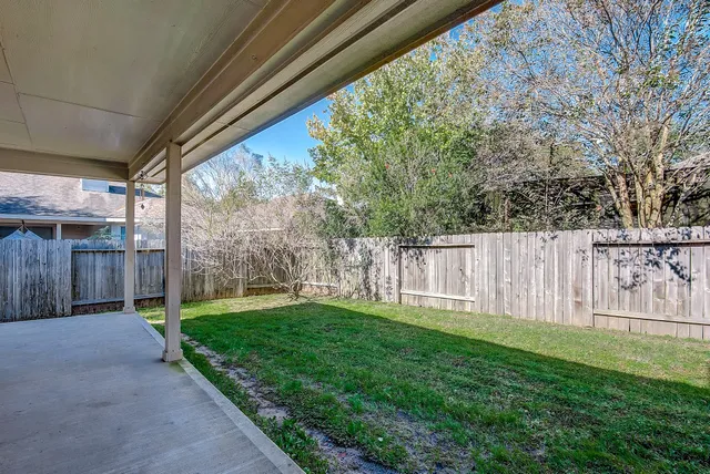 a view of a house with backyard and a tree