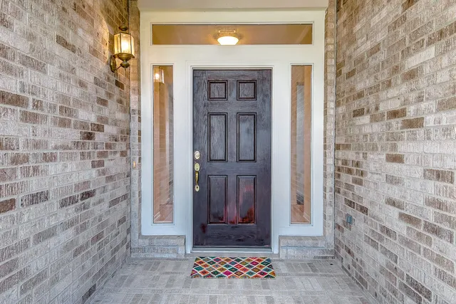 a view of a hallway with wooden floor and a bathroom