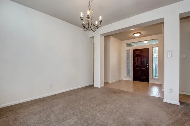 a view of a chandelier in big room and a bathroom