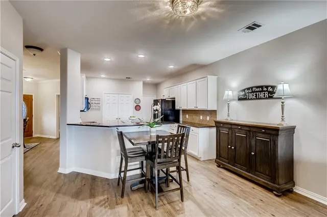 a kitchen with a table chairs refrigerator and microwave