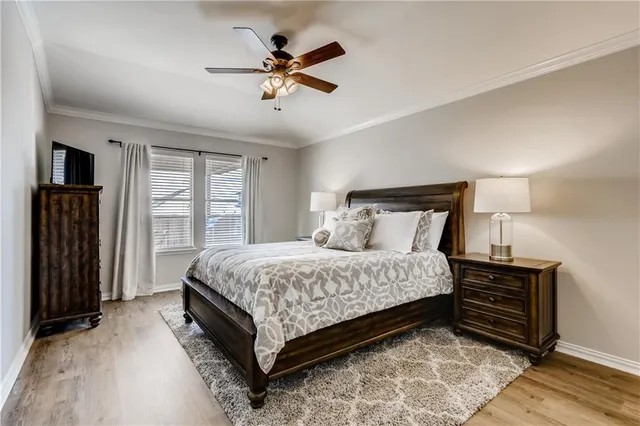 a spacious bedroom with a bed a dresser and a chandelier