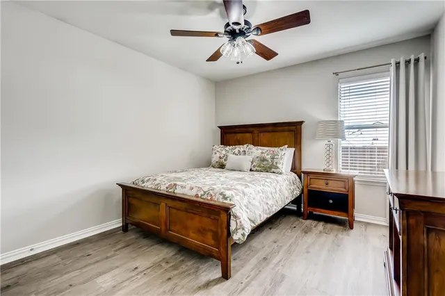a bedroom with a bed and a ceiling fan