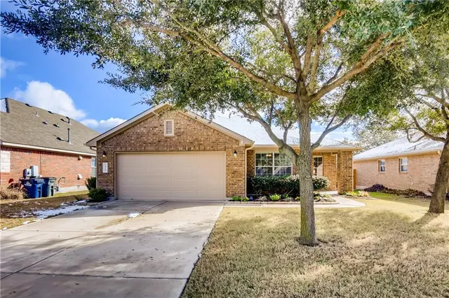 a front view of house with yard and trees around
