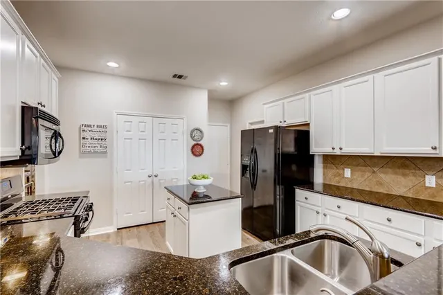 a kitchen with a sink cabinets and stainless steel appliances