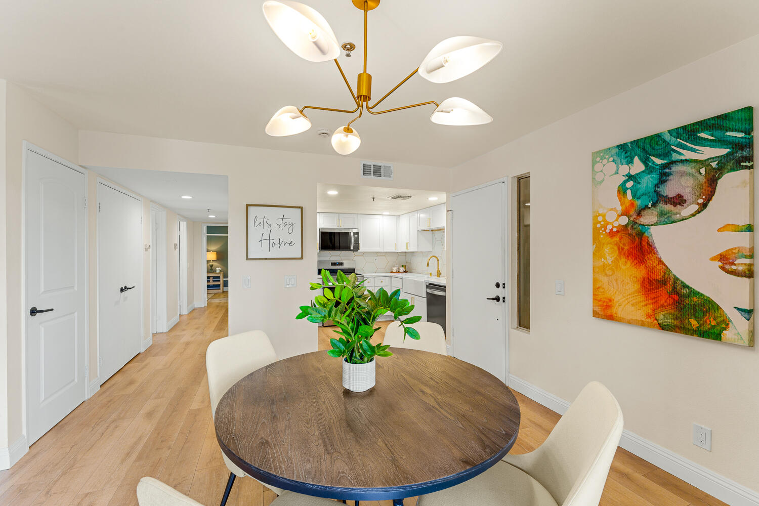 200 East Racquet Club Road, Unit 60 Palm Springs, CA 92262 - Photo 16 of 48 a view of a dining room with furniture a potted plant and wooden floor