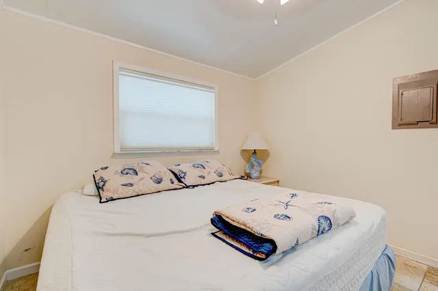 a bedroom with a bed and a large window