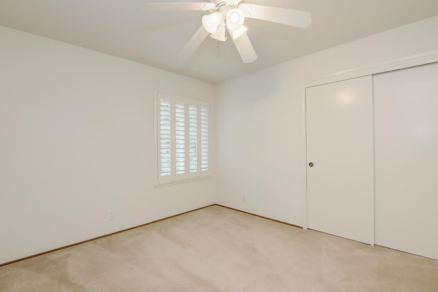 950 Boranda Avenue, Unit 10 Mountain View, CA 94040 - Photo 11 of 20 an empty room with a chandelier fan and windows