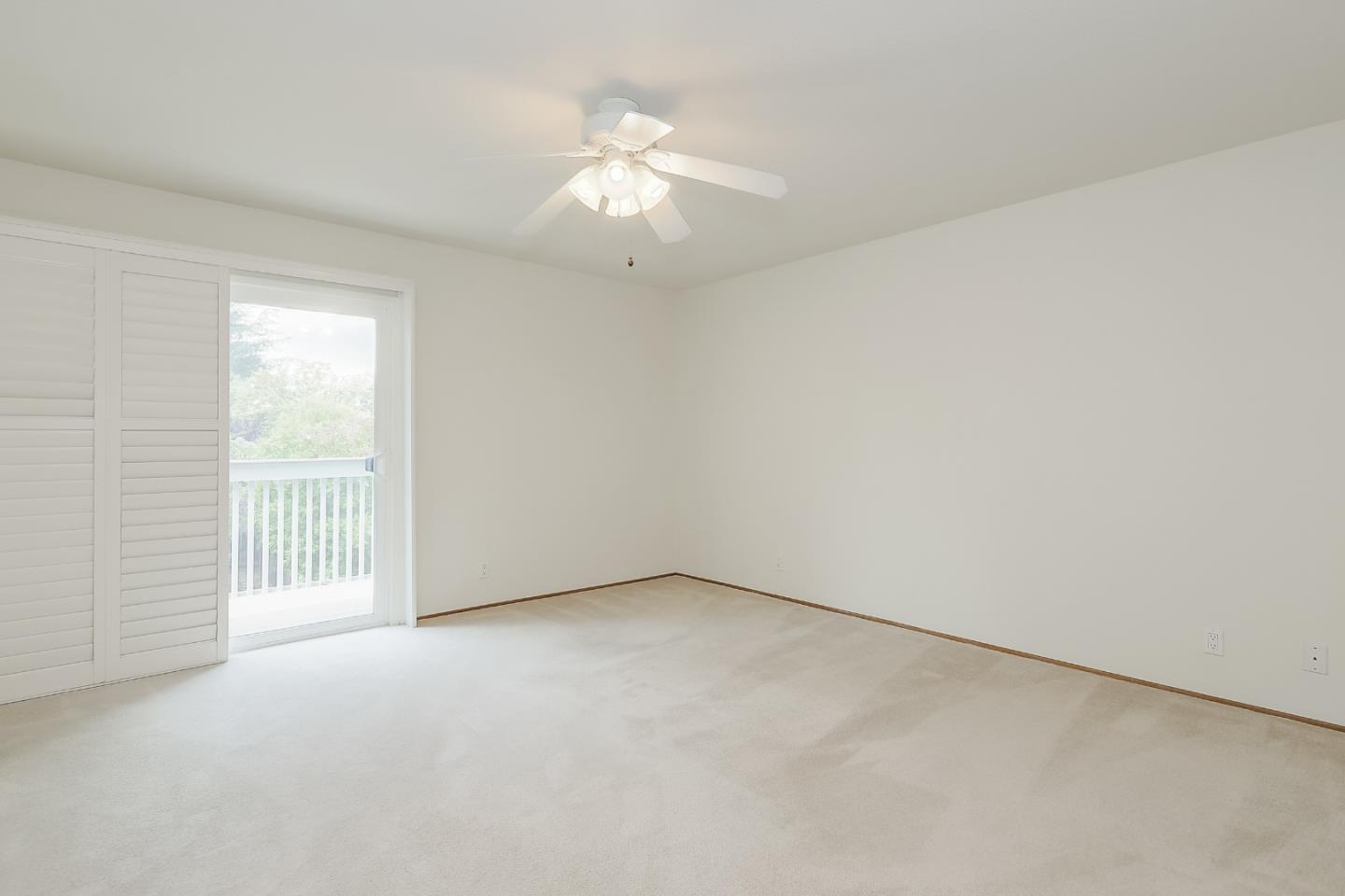 950 Boranda Avenue, Unit 10 Mountain View, CA 94040 - Photo 14 of 20 an empty room with a chandelier fan and windows