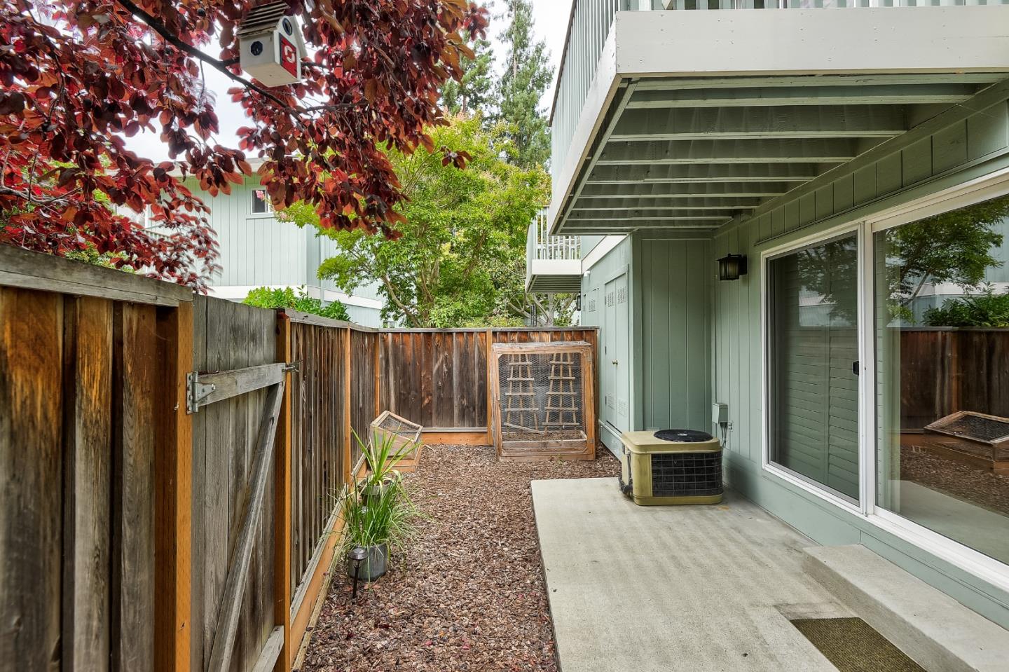 950 Boranda Avenue, Unit 10 Mountain View, CA 94040 - Photo 19 of 20 a view of a backyard with chairs and floor to ceiling window and wooden fence
