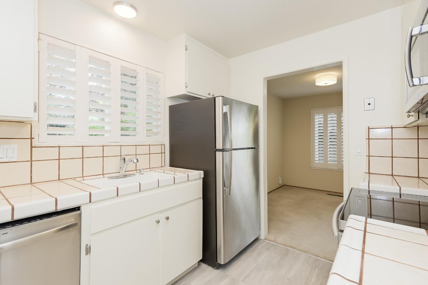 950 Boranda Avenue, Unit 10 Mountain View, CA 94040 - Photo 5 of 20 a kitchen with a refrigerator and a sink