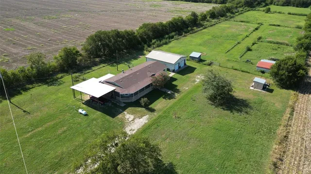 an aerial view of a house with pool yard and outdoor seating
