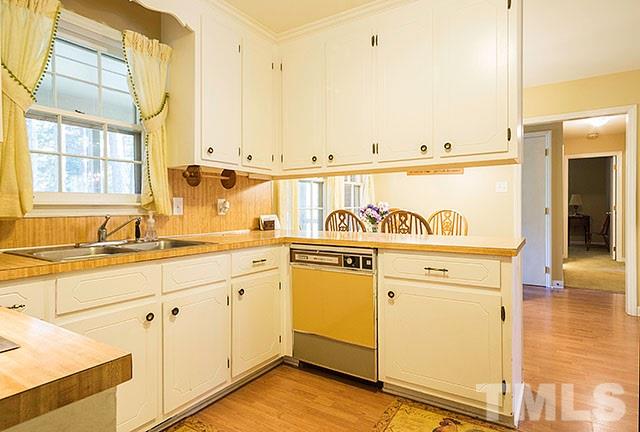 2709 Baptist Road Durham, NC 27703 - Photo 12 of 25 a view of a kitchen with granite countertop a sink and dishwasher with wooden floor