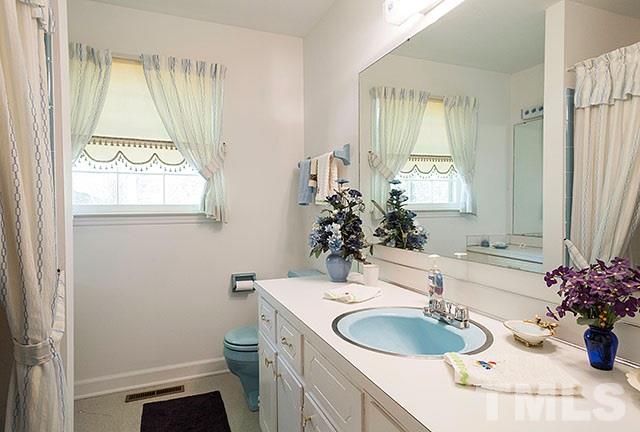 2709 Baptist Road Durham, NC 27703 - Photo 17 of 25 a bathroom with a granite countertop sink toilet and mirror