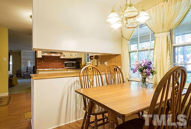 2709 Baptist Road Durham, NC 27703 - Photo 10 of 25 a dining room with furniture a chandelier and wooden floor