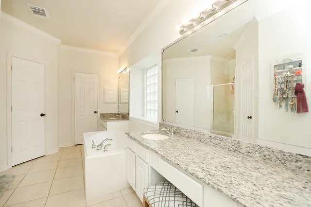 a spacious bathroom with a granite countertop sink a mirror and a shower