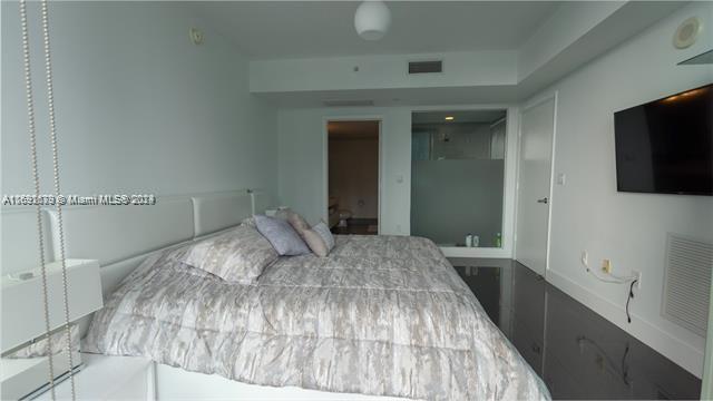92 Southwest 3rd Street, Unit 1802 Miami, FL 33130 - Photo 13 of 19 a bedroom with a bed and a flat tv screen on dresser